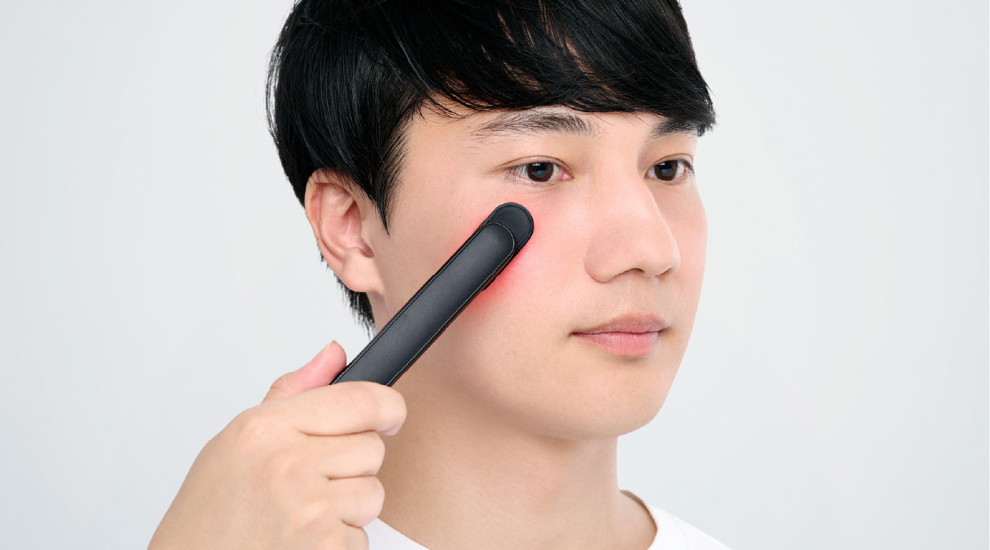DISM美顔器を目元にあてている男性のイメージ